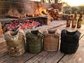 All four tactical beer koozies at a campfire - Camo, Olive Green, Tan and Black