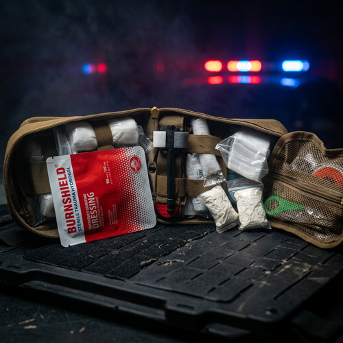 IFAK open contents against emergency scene background